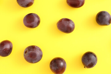 Red grapes isolated top view in yellow background