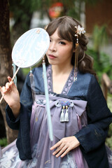 Beautiful young woman with dark blue Chinese lolita dress with Chinese garden