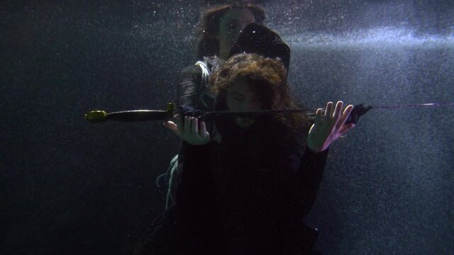 mysterious knighting underwater, medieval witch or queen is giving sword to brave knight