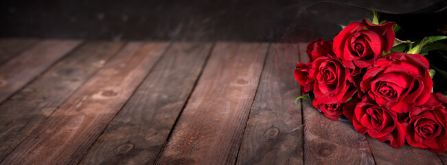 Bouquet of red roses on dark vintage planks. Horizontal background for romantc valentine's day...