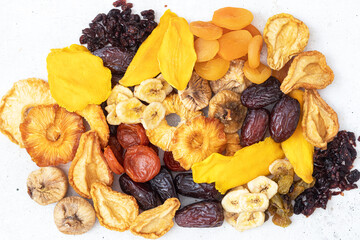 Mix of nuts and dried fruits on a  table. Dates, apricots,  figs, banana,  cranberries, raisins, pineapple, pear.