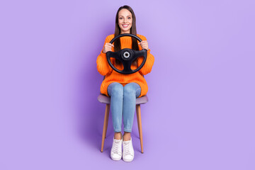Photo of positive lady hold steering wheel sit chair prepare pass exam wear orange sweater isolated...