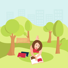 A young woman is lying in the park on the grass. Reading a book.