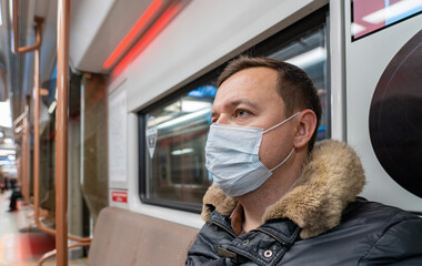 Portrait of male passenger wearing medical face mask in public transportation. Millennial man...