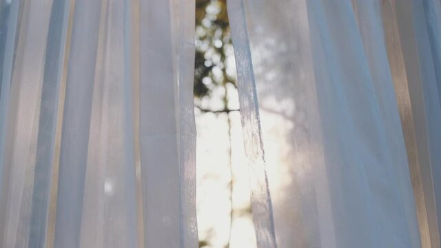 close-up of white transparent curtain fabric in wind blowing with sunshine in evening, texture background