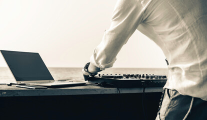 Disc jockey playing music for tourist people at club party outdoors on the beach - Dj at music live...