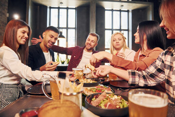 Caucasian ethnicity. Group of young friends sitting together in bar with beer