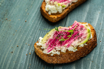 toast with chia seeds with sliced watermelon radish or chinese daikon, cottage cheese and microgreen. freeze motion. banner, catering menu recipe