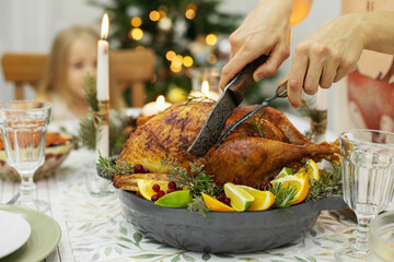 A festive New Year's table, on the table a Christmas turkey with oranges, aromatic herbs and cranberries