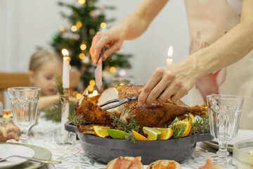 A festive New Year's table, on the table a Christmas turkey with oranges, aromatic herbs and cranberries