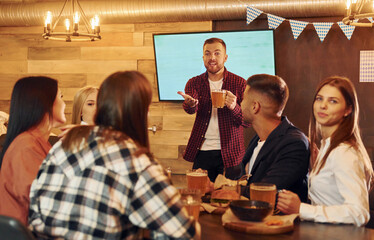 Positive facial expression. Group of young friends sitting together in bar with beer