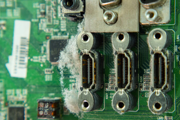 Green dusty TV board with three HDMI outputs. Close-up. Electronics repair shop.