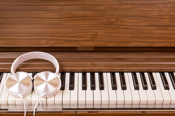 white headphone on classical piano keys. music background