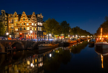 Fototapeta na wymiar Amsterdam Canal With Boats on a Cloudless Night