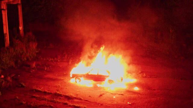 Filming area. Spectacular shot of guys firing old car exploding. Automobile explosion. Fantastic scene. Thriller movie night decorations. Drone flight.