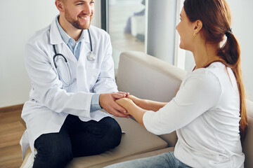 Obraz premium Holding patient by hands. Professional medic in white coat is in the clinic