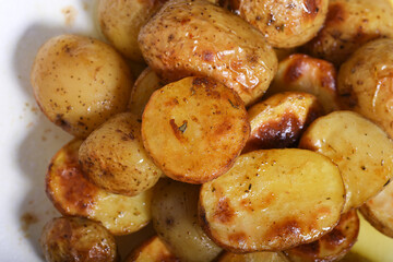 Potatoes baked in the oven stand on a white background