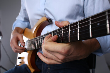 Fototapeta na wymiar Male hands are playing a wooden six mstring guitar
