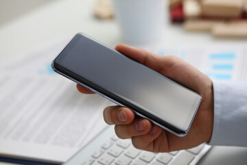 Businessman holds in hand new modern smartphone