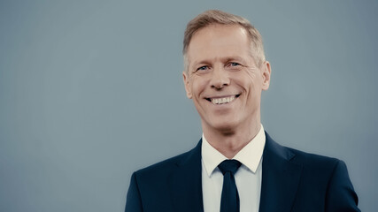 Smiling businessman in formal wear looking at camera isolated on grey. - obrazy, fototapety, plakaty