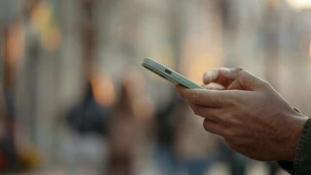 Close up of muslim man texting on mobile outdoors