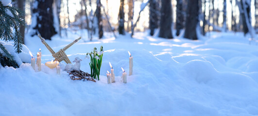 Wiccan altar for Imbolc sabbath, pagan holiday ritual. Brigid's cross of straw, candles, snowdrops,...