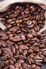 Obraz premium Heap of dark roasted coffee grains in jute bag