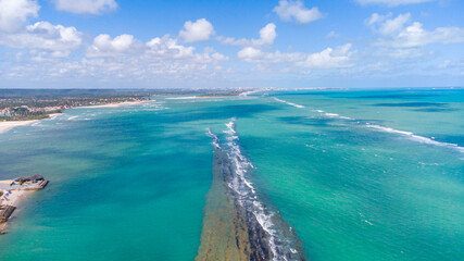 Fototapeta na wymiar Praia com piscinas naturais e água cristalina vista de drone