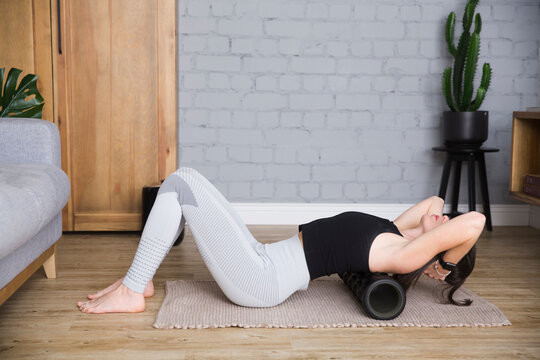 young woman stretches using foam roller. Woman exercise at home. a healthy lifestyle. sports at home 