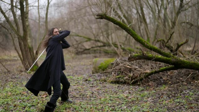 medieval fighter with sword in forest, black magician is fighting with invisible enemy