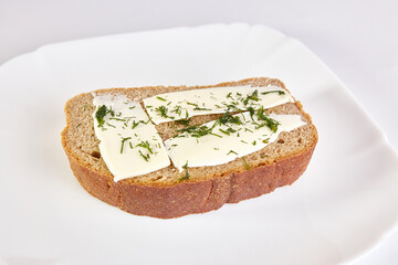 Sandwich of rye bread, butter and greens.