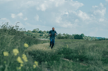 Ax in the hands of a medieval Viking warrior running across the field. Metal chain mail. Filming a historical film.