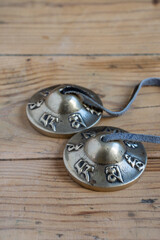 Top view of Tibetan cymbals on wooden table, vertical, with copy space