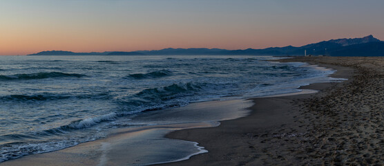 Sea and beach of Viareggio at sunset, with mountains in the background, with islands in the distance, Tuscany, Italy