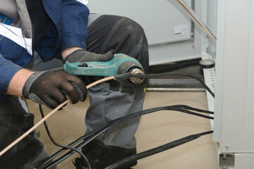 Installation of the cable sleeve heating wire insulation with an industrial hair dryer. Close-up