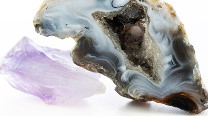 Agate geode with crystals and amethyst macro photography. Semiprecious stones isolated on a white background. Healing properties of agate and amethyst minerals.