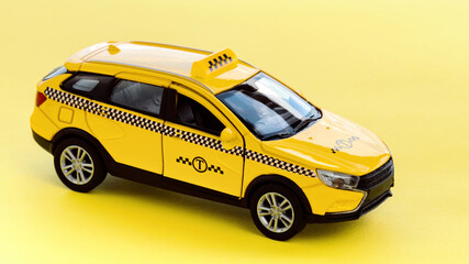Yellow taxi cab on a yellow background macro photography. Taxi car side view. Service for getting around the city by taxi. Taxi service use concept.