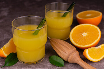 Fresh orange juice on a gray background.