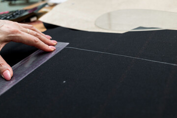 The dressmaker will open the fabric for the future costume for further work. Fashion designer tailor in the workshop of the studio, developing a new collection of clothes. 