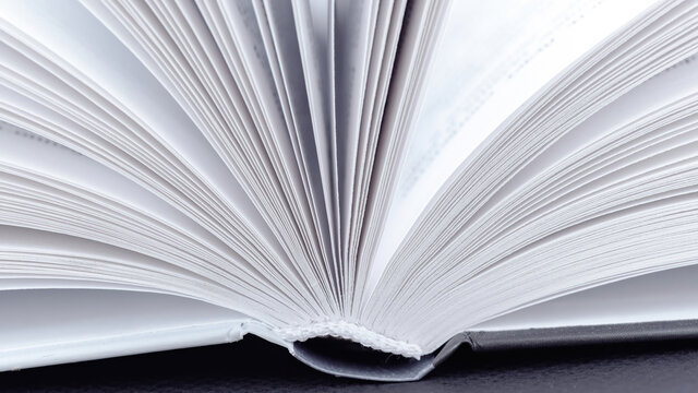 Book spine macro photography. Open book with white pages close-up with copy space. The concept of visiting libraries and reading various books, encyclopedias. Sustainable education concept.