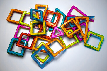 Details of a magnetic constructor made of plastic of different colors on a white isolate. An interactive game for children.