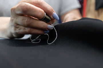 The dressmaker will open the fabric for the future costume for further work. Fashion designer tailor in the workshop of the studio, developing a new collection of clothes. 