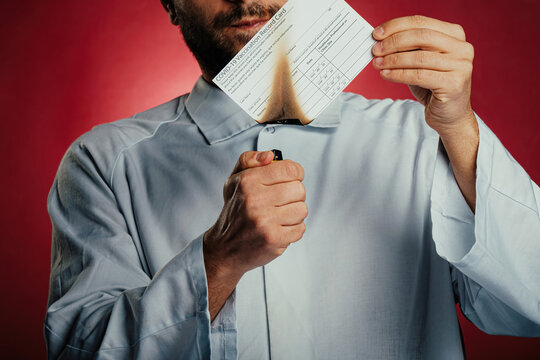 Man Or Doctor Holding And Burning A Covid-19 Vaccination Record Card. Concept Of High Rate Of Infection Due Omicron Stem.