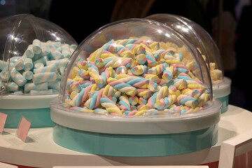 Marshmallows under a glass flask in a store of different shapes and colors