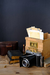 old family photos 50s, 40s, retro camera, books on wooden table, concept of genealogy, memory of...