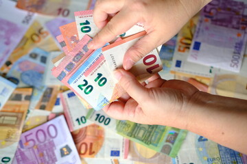 closeup female hands count paper euro banknotes of european union, paper bills on table, concept of cash, payments, savings, banking, save up for vacation, got low salary, social security, pay taxes