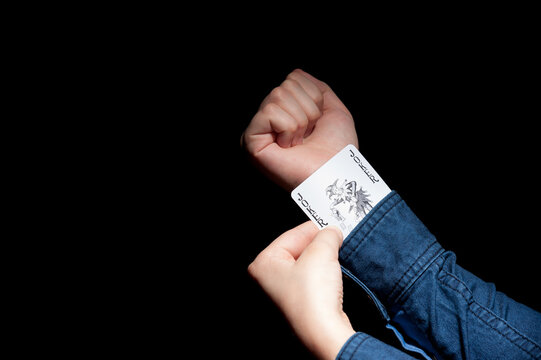 Lviv, Ukraine - 01.03.2022: human hands pulling a joker card from the sleeve