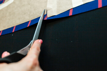 women's hands with scissors create a composition together with fabric, atelier