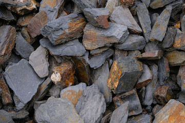 Slate stone for design. Dark gray stones with rusty spots.