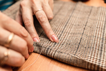 The dressmaker will open the fabric for the future costume for further work. Fashion designer tailor in the workshop of the studio, developing a new collection of clothes. 